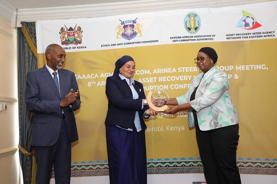 Munira Ali receiving a plaque from the President EAAACA